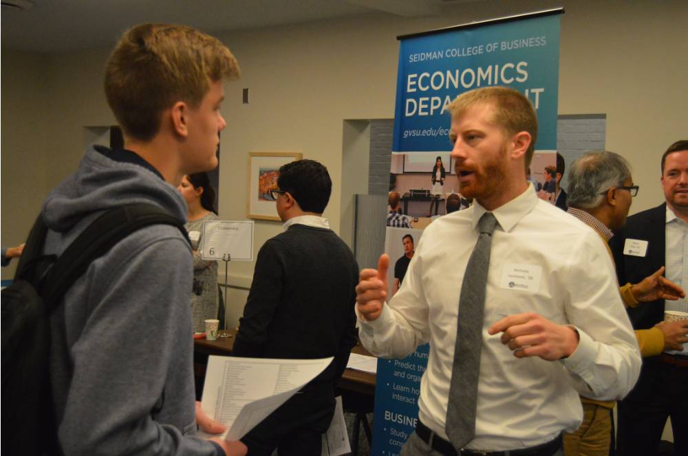 An alumnus talking to a student at the Academic Major Fair.